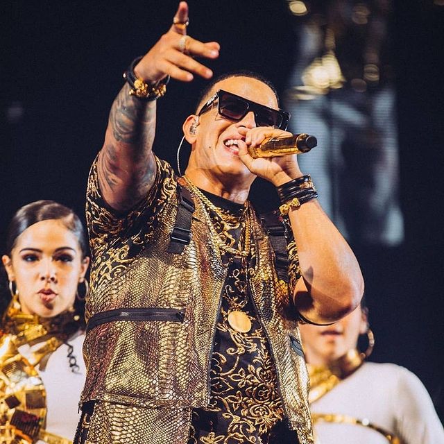daddy yankee wearing a golden and black mixed tee and half jacket.